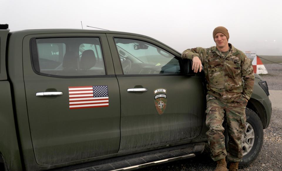 While deployed to Camp Bondsteel, Kosovo, in support of Operation Joint Guardian, Sgt. Benjamin Campbell, Task Force Nighthawk, 76 Infantry Brigade Combat Team, Indiana Army National Guard, poses next to his assigned vehicle, December 21, 2022. Sgt. Campbell’s primary task involve route reconnaissance and planning, and the safe transport of staff members.