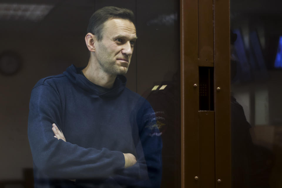 In this photo provided by the Babuskinsky District Court, Russian opposition leader Alexei Navalny stands in a cage during a hearing on his charges for defamation, in the Babuskinsky District Court in Moscow, Russia, Friday, Feb. 5, 2021. Russian opposition leader Alexei Navalny appeared in a Moscow court on Friday for the second time this week, this time on a charge of slandering a World War II veteran. The politician, who was ordered earlier this week to serve two years and eight months in prison, slammed the hearing as a "disgusting PR trial" intended by the Kremlin to disparage him. (Babuskinsky District Court Press Service via AP)