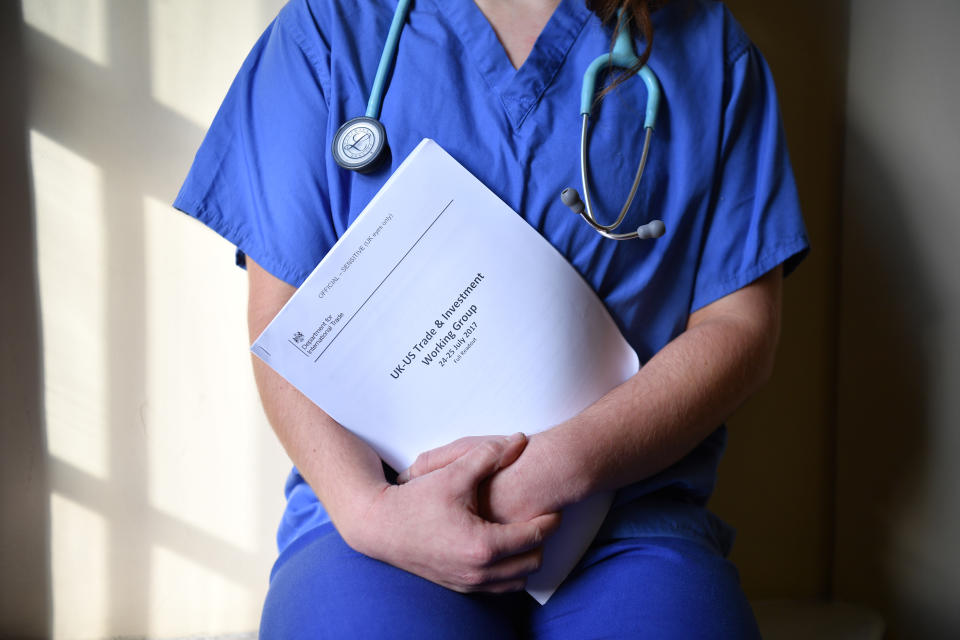 A member of NHS medical staff poses with unredacted documents related to post-Brexit UK-US Trade talks following a Labour election policy announcement on the NHS at church house n Westminster on November 27, 2019 in London, England. Photo: Leon Neal/Getty Images