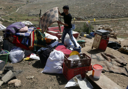 A Palestinian collects his belonging after Israeli forces demolished a shelter he used to live in with his family in Khirbet Tana near the West Bank city of Nablus April 7, 2016. REUTERS/Abed Omar Qusini