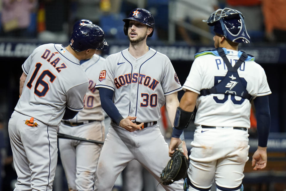 Houston Astros' Kyle Tucker (30) celebrates with Aledmys Diaz (16) after his two-run home run off Tampa Bay Rays relief pitcher Brooks Raley during the eighth inning of a baseball game Wednesday, Sept. 21, 2022, in St. Petersburg, Fla. Looking on is catcher Rene Pinto. (AP Photo/Chris O'Meara)