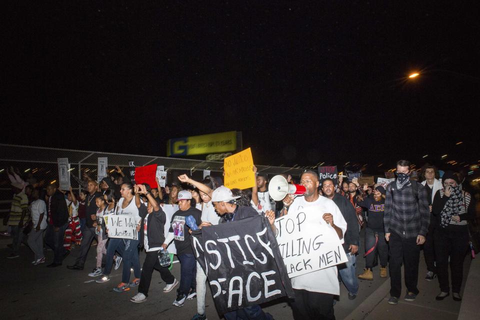 Demonstrators cross the 7th avenue bridge in downtown Phoenix the week after an unarmed man was shot dead by police, in Phoenix, Arizona December 8, 2014. Police say Rumain Brisbon, 34, was killed on December 2 as he struggled with a policeman who suspected he was selling drugs and erroneously believed he felt the handle of a gun in the man's pocket. Brisbon was actually carrying a pill bottle, and an attorney for his mother said accounts from witnesses did not tally with the police version. REUTERS/Deanna Dent (UNITED STATES - Tags: CRIME LAW CIVIL UNREST)