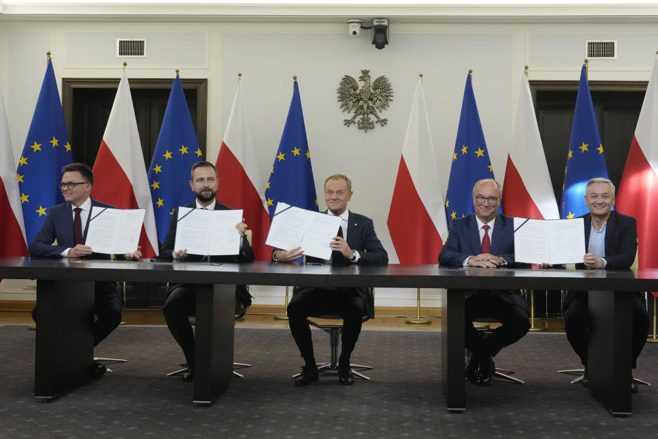 Szymon Holownia, left, head of the Poland 2050 party, Wladyslaw Kosiniak-Kamysz, head of the Polish People's Party, Donald Tusk, center, head of the Civic Coalition, Wlodzimierz Czarzasty, a co-chairman of the New Left party, and Robert Biedron, the other co-chairman of the New Left, sign a coalition agreement, in Warsaw, Poland, on Friday Nov. 10, 2023. The leaders of Polish opposition parties have signed a coalition agreement that lays out a roadmap for governing the nation over the next four years. (AP Photo/Czarek Sokolowski)