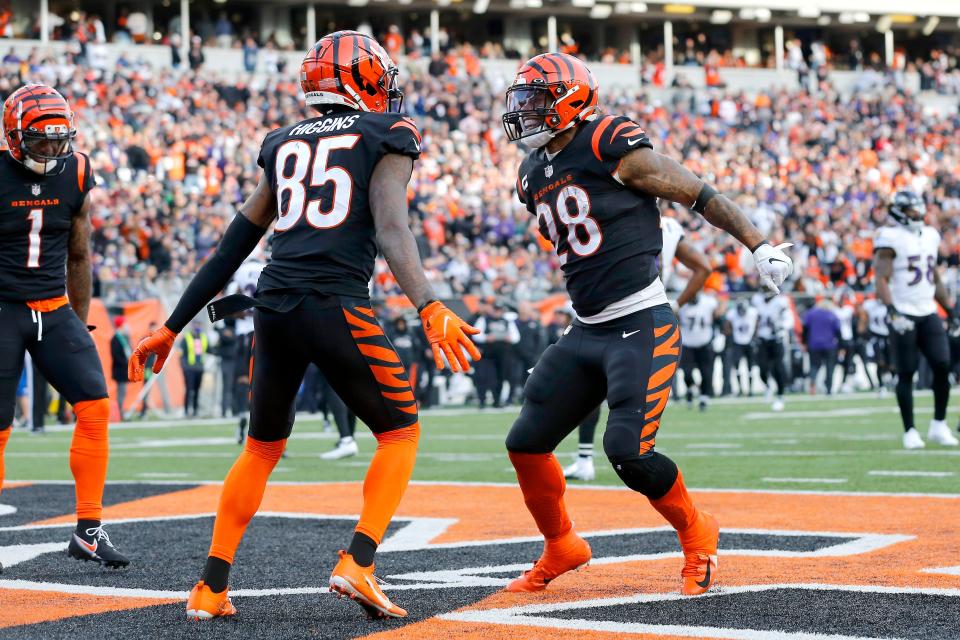 Cincinnati Bengals wide receiver Tee Higgins (85) celebrates with running back Joe Mixon (28) after scoring a touchdown against the Baltimore Ravens during the fourth quarter at Paul Brown Stadium.