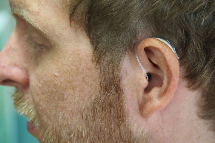 A man wears a hearing aid.