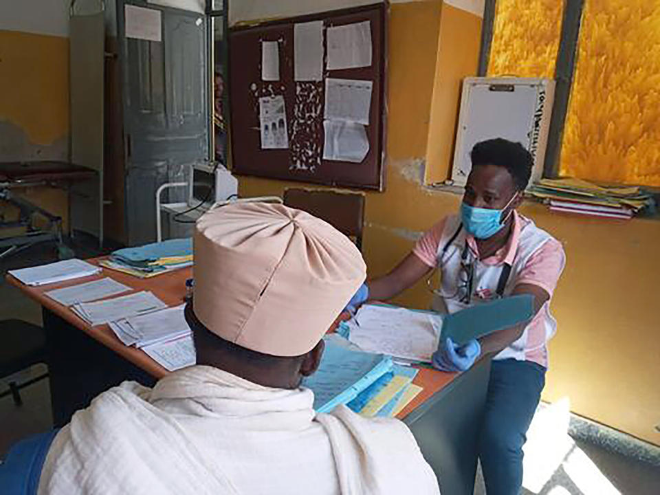 In this Thursday Dec.31, 2020, photo provided by Medecins Sans Frontieres, a Medecins Sans Frontieres staff member speks to a patient in Adigrat, in Tigray, northern Ethiopia. From “emaciated” refugees to crops burned on the brink of harvest, starvation threatens the survivors of more than two months of fighting in Ethiopia’s Tigray region. Authorities say more than 4.5 million people, or nearly the entire population, need emergency food. The first humanitarian workers to arrive after weeks of pleading with Ethiopia for access describe weakened children dying from diarrhea after drinking from rivers, and shops that were looted or depleted weeks ago. (Medecins Sans Frontieres via AP)