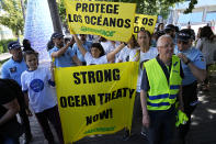 Portuguese police lead away Greenpeace activists that tried to paste big posters by the entrance to the venue hosting the United Nations Ocean Conference in Lisbon, Thursday, June 30, 2022. From June 27 to July 1, the United Nations is holding its Oceans Conference in Lisbon expecting to bring fresh momentum for efforts to find an international agreement on protecting the world's oceans. (AP Photo/Armando Franca)