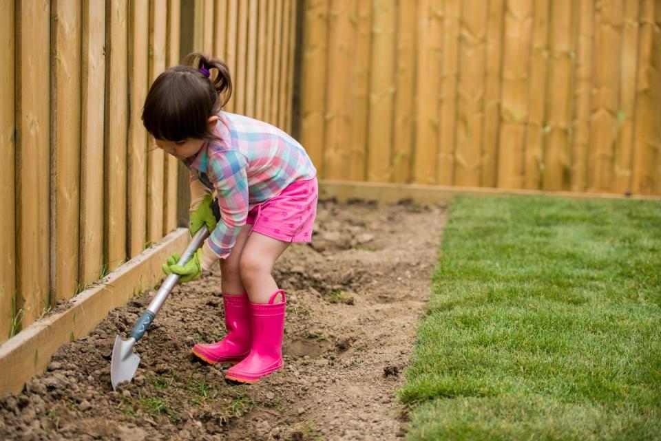 summer activities young girl digging in the garden