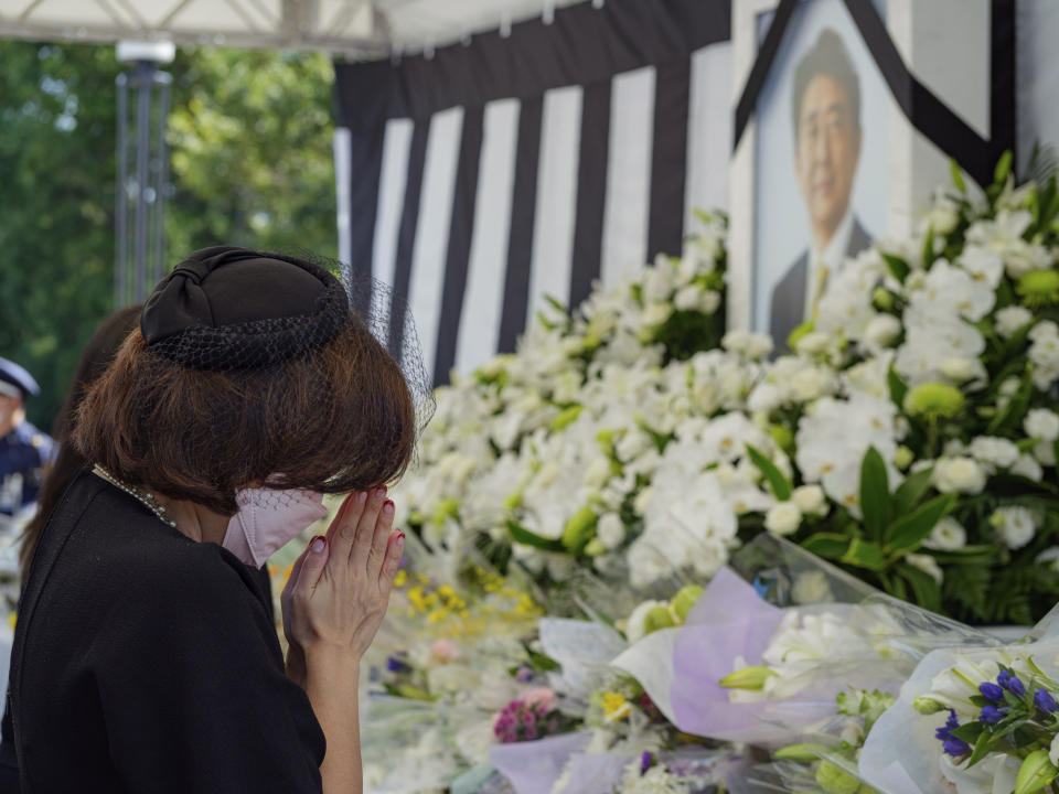 People pay their respects to former Japanese Prime Minister Shinzo Abe outside the Nippon Budokan in Tokyo Tuesday, Sept. 27, 2022, ahead of his state funeral later in the day. (Nicolas Datiche/Pool Photo via AP)