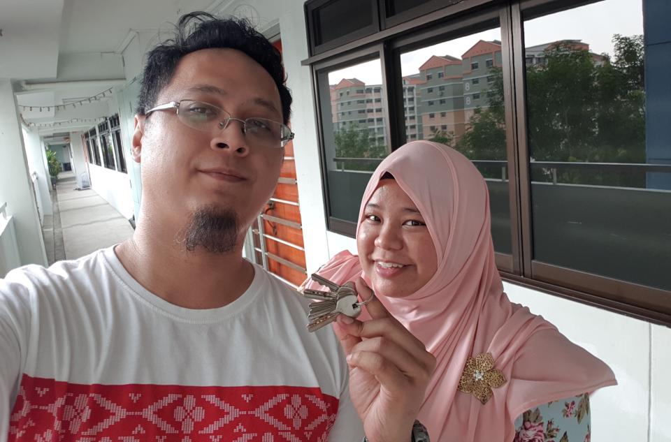 Liyana (right) and her current husband Muhammad Faizal Sugi holding the keys to their four-room HDB flat in Woodlands in September 2018. (PHOTO: Muhammad Faizal Sugi)