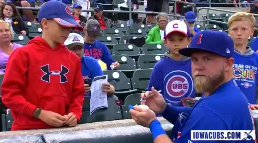 Taylor Davis might be signing a ball for a young fan, but he knows the camera is there. (Twitter/@IowaCubs)