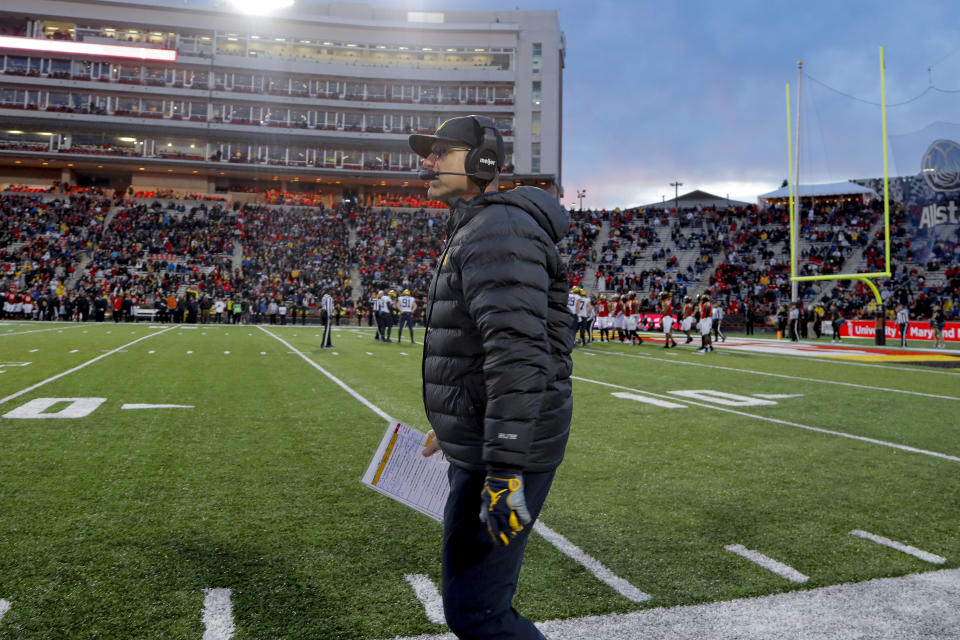 FILE - Michigan coach Jim Harbaugh walks along the sideline during the first half of the team's NCAA college football game against Maryland, Nov. 20, 2021, in College Park, Md. Harbaugh will be the coach of the Los Angeles Chargers, leaving Michigan after capping his ninth season as coach of college football’s winningest program with the school’s first national championship since 1997, two people familiar with the situation told The Associated Press. The people spoke to the AP on condition of anonymity because the team hasn’t made the announcement. (AP Photo/Julio Cortez, File)