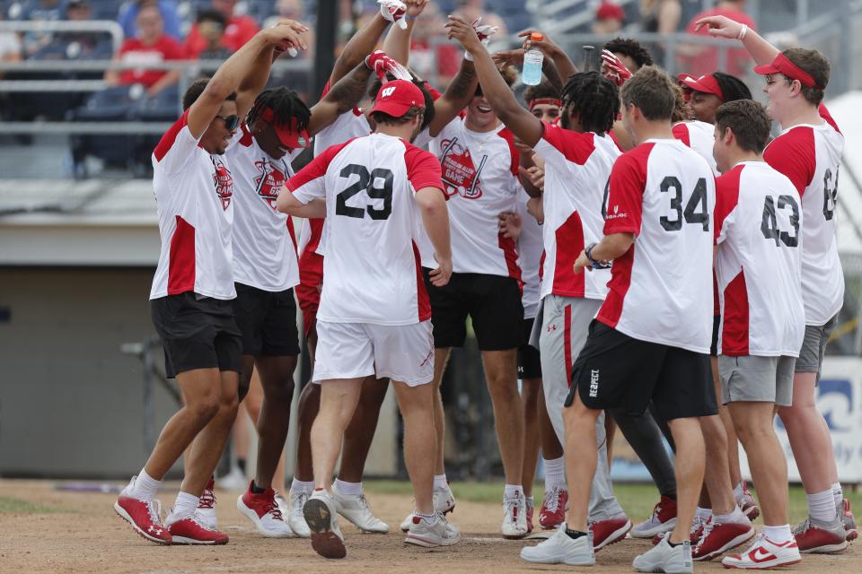 Brady Schipper (29) is greeted by teammates after hitting a home run during the Braelon Allen Charity Softball Game July 17, 2022, in Fond du Lac, Wis.