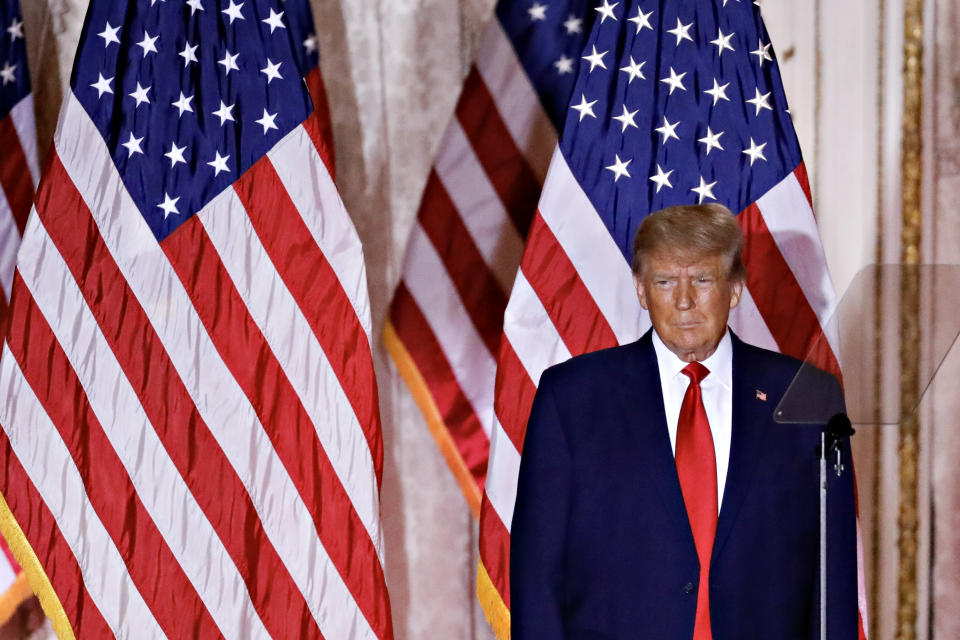 Trump stands onstage in front of two American flags.