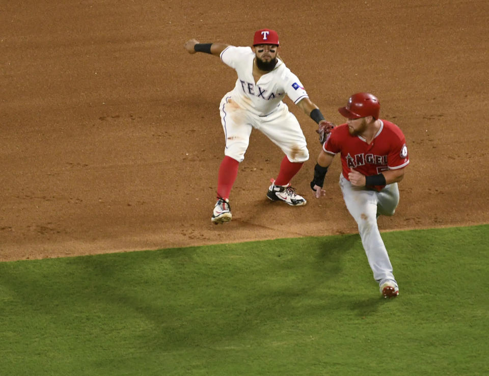 Texas Rangers second baseman Rougned Odor tags out Los Angeles Angels' David Fletcher for the third out of a triple play on a ground ball by Fletcher off Texas Rangers starting pitcher Ariel Jurado during the fourth inning of a baseball game Thursday, Aug. 16, 2018, in Arlington, Texas. Taylor Ward and Eric Young Jr. were also out on the play. (AP Photo/Jeffrey McWhorter)
