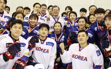 South Korean President Moon Jae-in poses for photographs with South Korean women's and men's ice hockey team players during his visit to Jincheon National Training Center in Jincheon, South Korea January 17, 2018. Picture taken January 17, 2018.   Yonhap via REUTERS