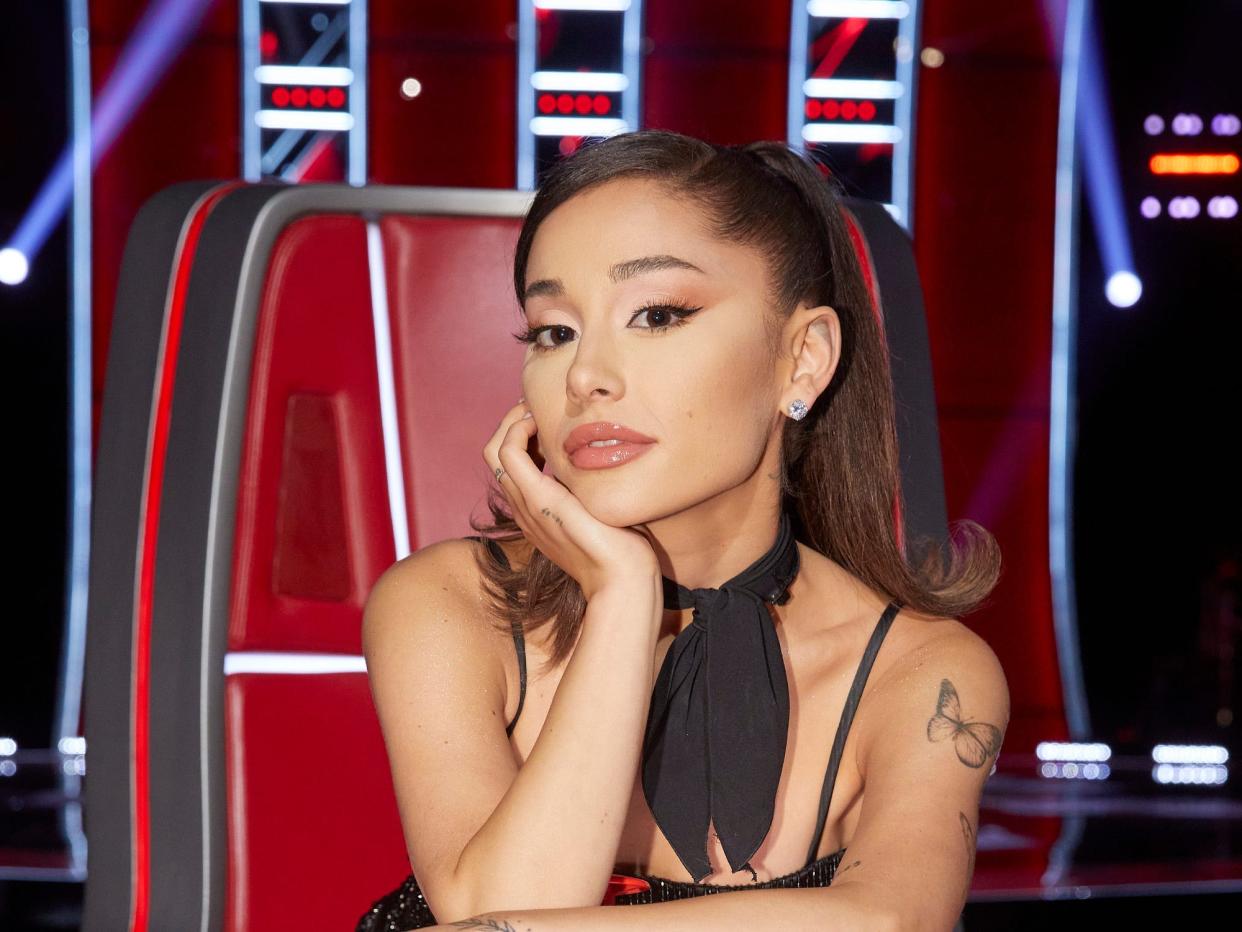 ariana grande posing for a photo in a coach chair on the voice