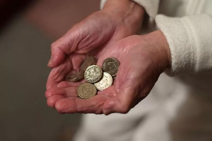 Older person holding pound coins