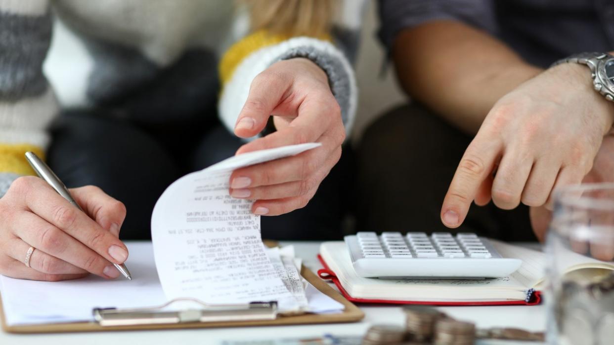 Close-up view of man and woman making account of family income.