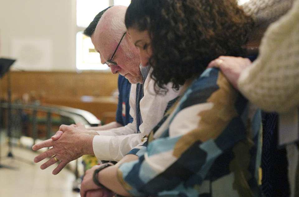 First United Methodist Church congregants pray for members attending the United Methodist General Conference, including Tracy Merrick, left, a delegate representing Western Pennsylvania, The Rev. Anais Hussian, a reserve delegate, and Joshua Popson, who is advocating for LGBTQ inclusion with the Love Your Neighbor Coalition, Sunday, April 14, 2024, in Pittsburgh. The 11-day conference is the denomination's first legislative gathering since a special session in 2019. (AP Photo/Jessie Wardarski)