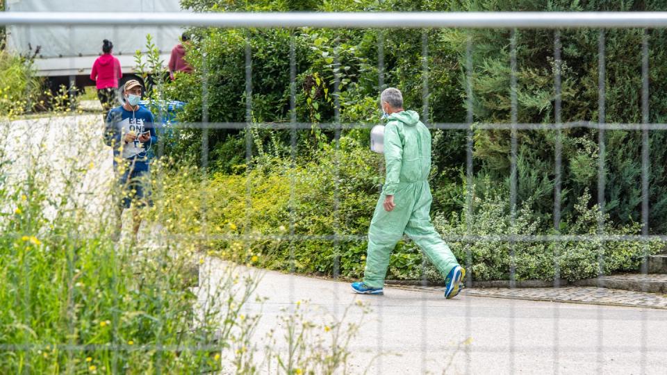 Ein Mann in Schutzanzug auf dem Gelände des betroffenen Bauernhofs.