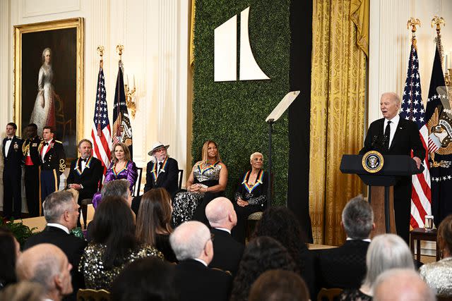 <p>Brendan Smialowski/AFP via Getty</p> Actor and comedian Billy Crystal, opera soprano Renee Fleming, singer-songwriter Barry Gibb, musician and actress Queen Latifah, and singer Dionne Warwick look on as President Joe Biden delivers remarks during a reception for the 46th Kennedy Center Honors Gala, in the East Room of the White House in Washington, D.C, on December 3, 2023.