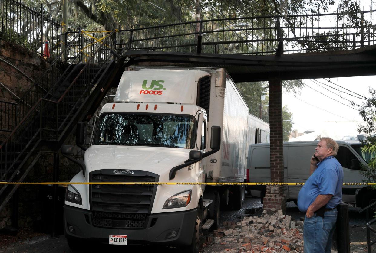 A restaurant delivery truck becam lodged under a walk bridge to the Olde Harbour Inn on Friday December 9, 2022 as the driver attempted to drive through a tight lane along lower Factors Walk.