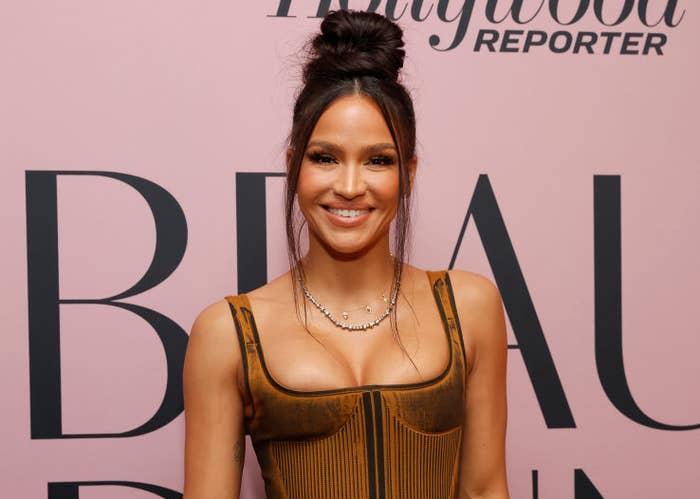 Cassie attends a Hollywood Reporter event, wearing a structured bodice top and a long skirt, holding a black clutch purse, and sporting a high bun hairstyle