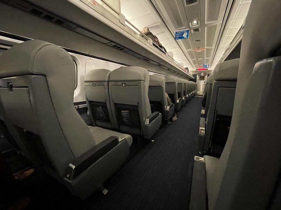 Rows of empty passenger seats. Many are empty.