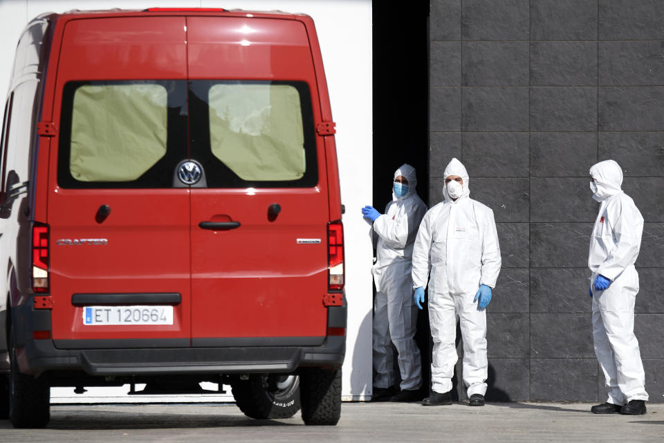 Workers in full protective gear wait to receive bodies at the ice rink. Source: Getty