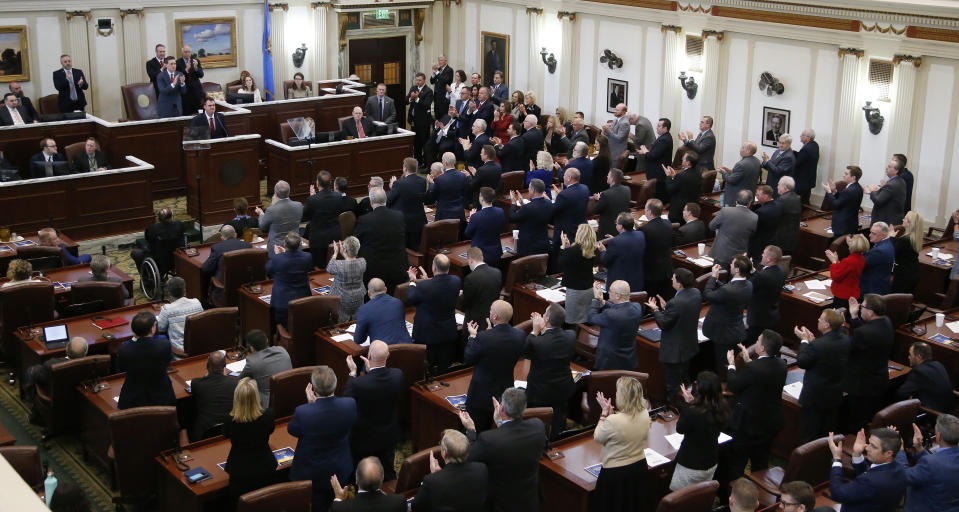 Oklahoma Gov. Kevin Stitt stands at a lectern as he is applauded during his State of the State address in Oklahoma City, Monday, Feb. 4, 2019. (AP Photo/Sue Ogrocki)