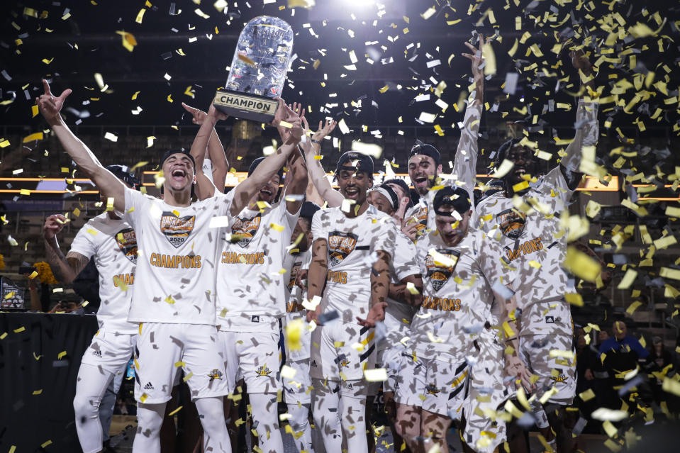 Northern Kentucky players celebrate with the trophy after a 71-62 win over Illinois-Chicago in an NCAA college basketball game for the Horizon League men's tournament championship in Indianapolis, Tuesday, March 10, 2020. (AP Photo/Michael Conroy)