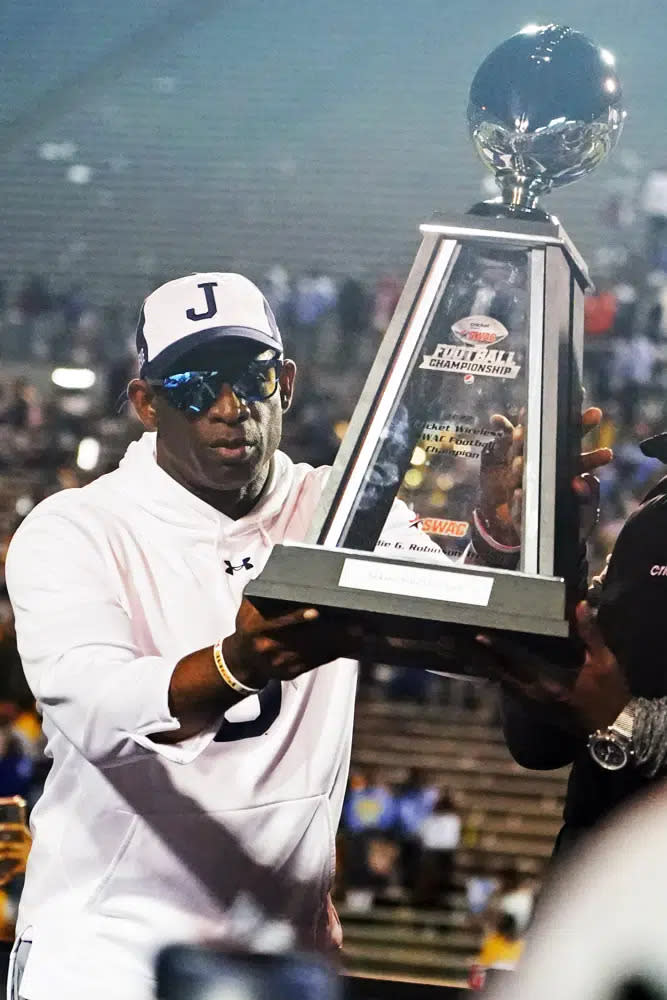 Jackson State head coach Deion Sanders hoists the winner’s trophy following the Southwestern Athletic Conference championship NCAA college football game against Southern University, Saturday, Dec. 3, 2022, in Jackson, Miss. Jackson State won 43-24. (AP Photo/Rogelio V. Solis)