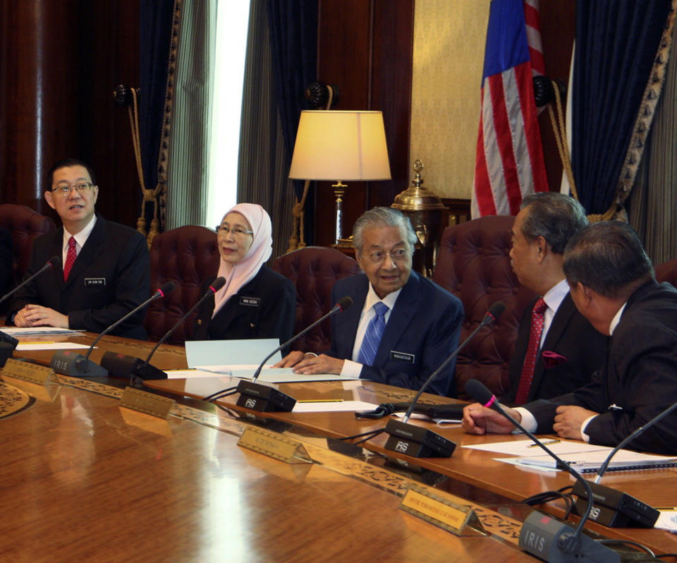 In this photo released by Malaysia Minister of Economic Affairs Azmin Ali Office, Malaysian Prime Minister Mahathir Mohamad, third right, chairs the first cabinet meeting with the new Malaysia cabinet members in Putrajaya, Malaysia Wednesday, May 23, 2018. (Malaysia Minister of Economic Affairs, Azmin Ali Office via AP)