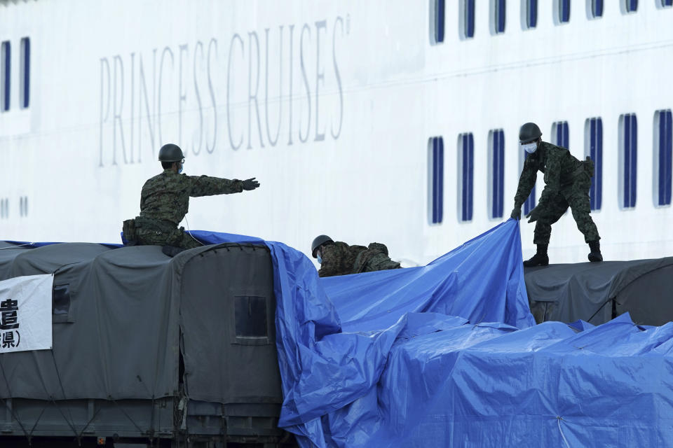 Members of the Japan Self Defense Forces prepare the truck to connect with the cruise ship Diamond Princess anchored off the Yokohama Port in Yokohama, near Tokyo Monday, Feb. 10, 2020. China reported a rise in new virus cases on Monday, possibly denting optimism disease control measures that have isolated major cities might be working, while Japan reported dozens of new cases aboard a quarantined cruise ship. (AP Photo/Eugene Hoshiko)