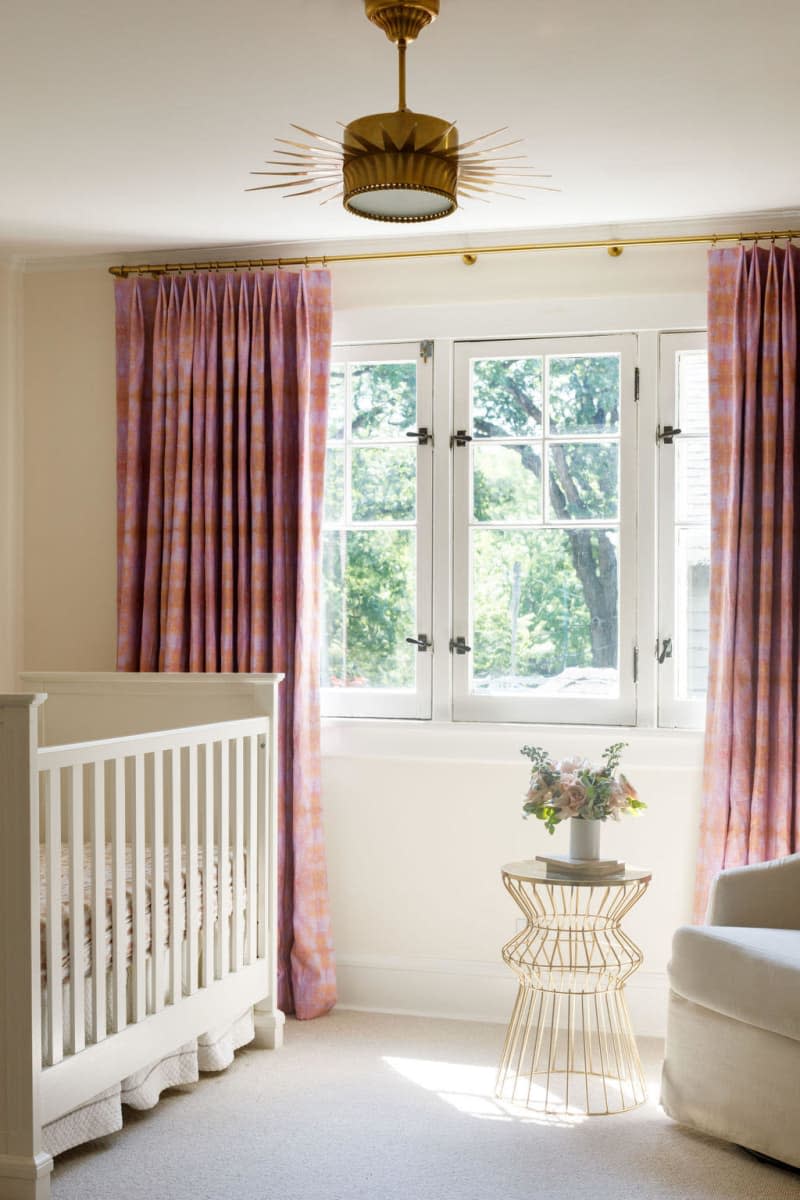 white crib, white carpet, red curtains, vintage inspired over head light