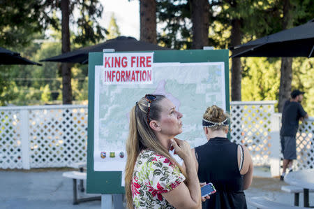 Judy Watt, who said she just purchased her dream home in Pollock Pines, watches smoke from the King Fire in Pollock Pines, California September 16, 2014. REUTERS/Noah Berger