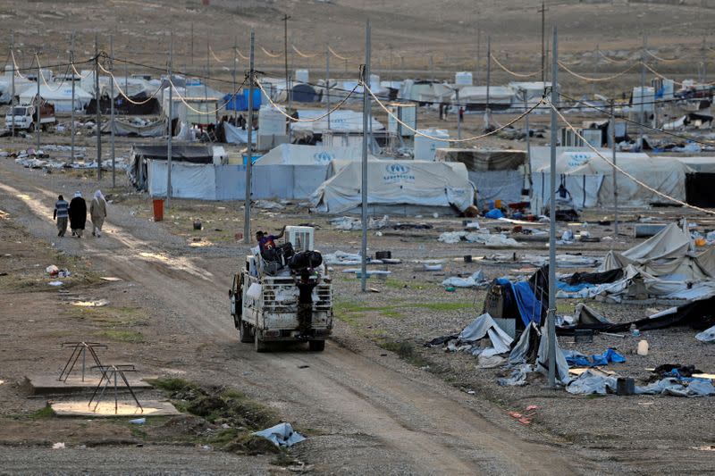 Displaced Iraqis ride on a truck as they are evacuated, at Hammam Al-Alil camp, south of Mosul