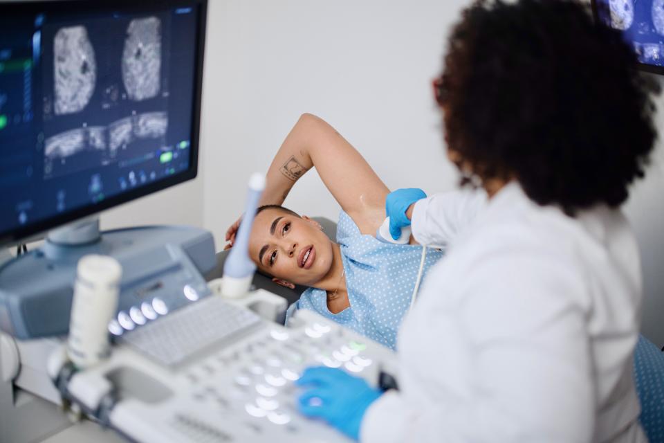 A young woman is doing a breast ultrasound for preventive breast cancer care