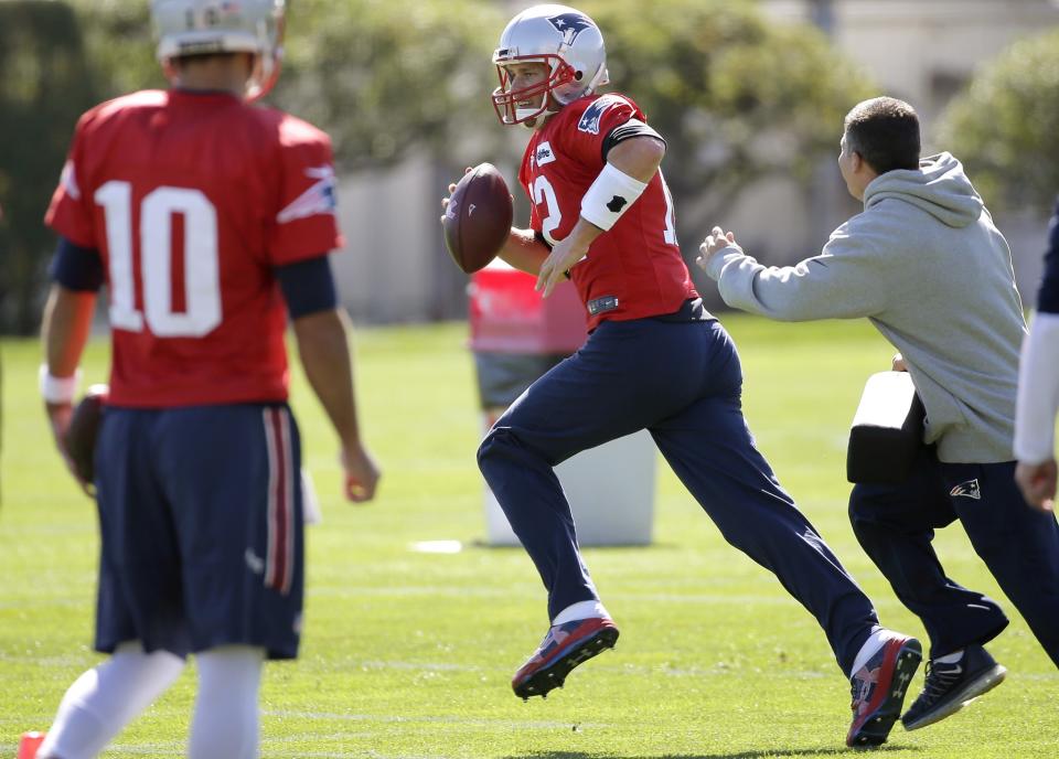 New England Patriots quarterback Tom Brady (12), center, performs field drills as quarterback Jimmy Garoppolo (10) looks on during an NFL football team practice Wednesday, Oct. 5, 2016, in Foxborough, Mass. (AP Photo/Steven Senne)