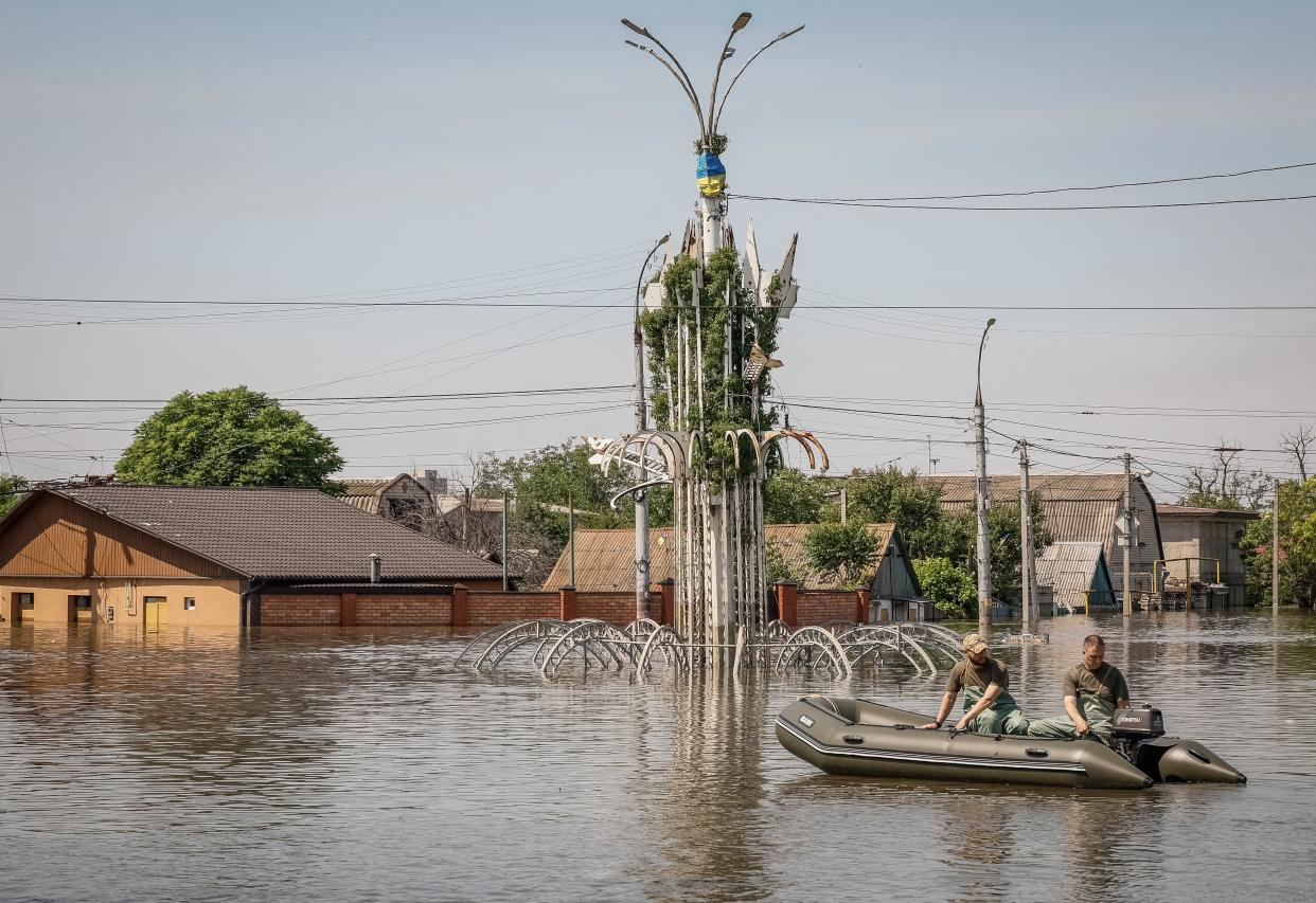 Volunteers sail on a boat during an evacuation of local residents from a flooded area after the Nova Kakhovka dam breached (REUTERS)