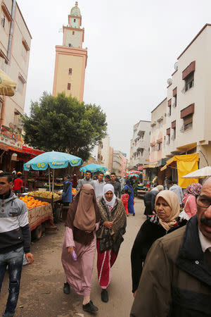 People walk past a fruit and vegetable stall at the market in Ouled Moussa district, on the outskirts of Rabat, Morocco April 24, 2018. REUTERS/Youssef Boudlal