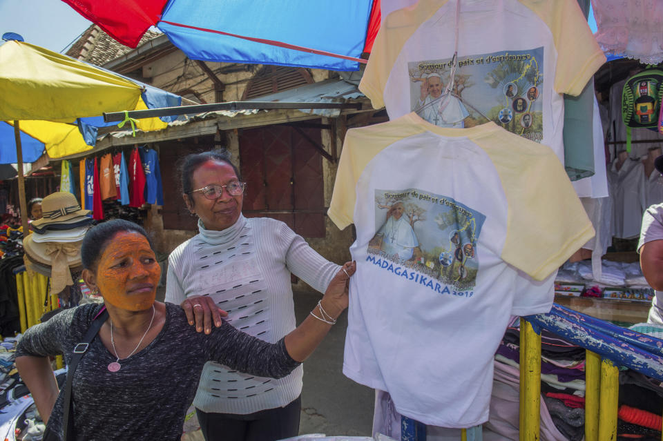 Women look at Pope paraphernalia at a stall in Antananarivo Tuesday, Sept. 3, 2019. Pope Francis heads this week to the southern African nations of Mozambique, Madagascar and Mauritius, visiting some of the world's poorest countries that have been hard-hit by some of his biggest concerns: conflict, corruption and climate change. (AP Photo/Alexander Joe)