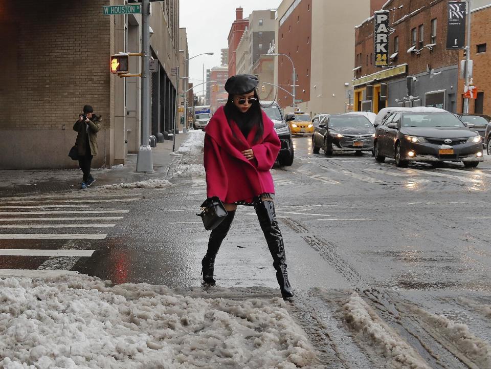 A woman sidesteps slush as she crosses a street on her way to a fashion show at the Skylight Clarkson Square during fashion week, Thursday, Feb. 9, 2017, in New York. (AP Photo/Julie Jacobson)