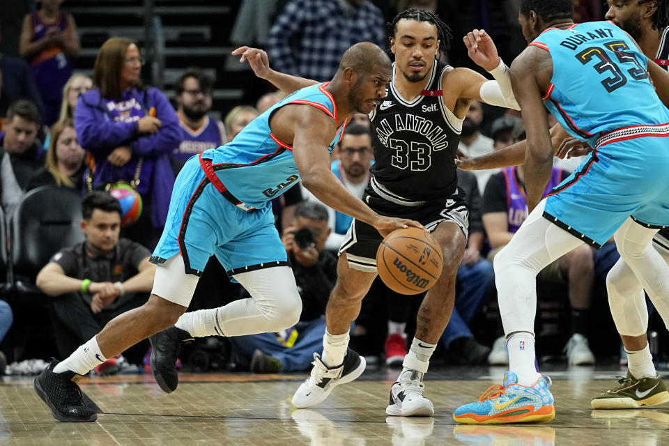 Phoenix Suns guard Chris Paul drives as San Antonio Spurs guard Tre Jones (33) defends during the first half of an NBA basketball game, Tuesday, April 4, 2023, in Phoenix. (AP Photo/Matt York)