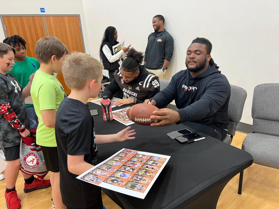 Navarre High grad and LSU defensive tackle Jordan Jefferson signs autographs for kids at Gateway Church of Christ during a visit Wednesday, Jan. 24, 2024, by Reese's Senior Bowl players.