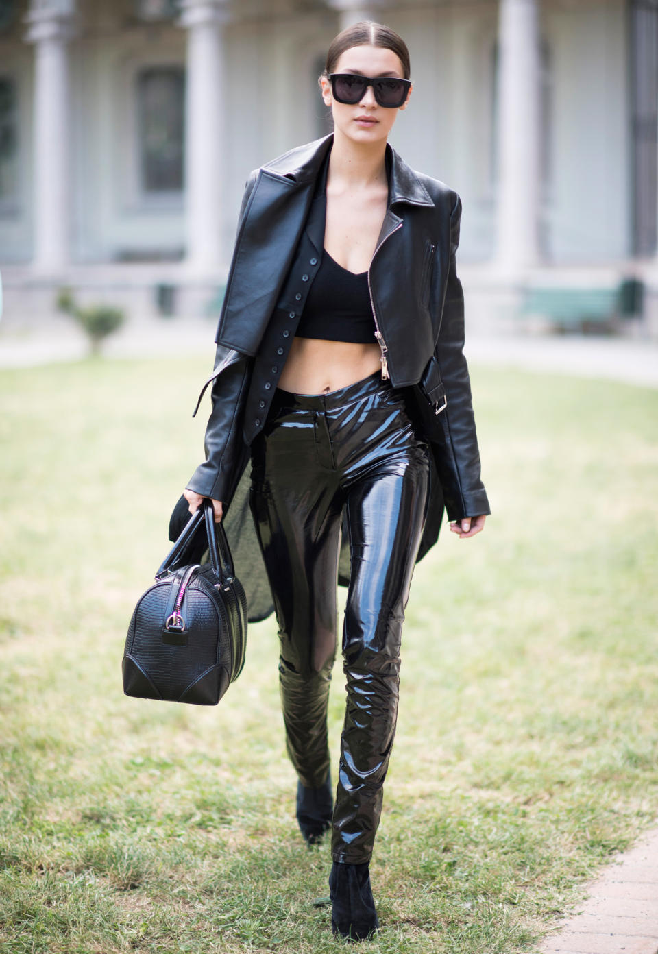 <p>Hadid went all-black during Milan Fashion Week in a pair of latex pants that she styled with a leather jacket, crop top, heeled booties, and a leather bag.</p>