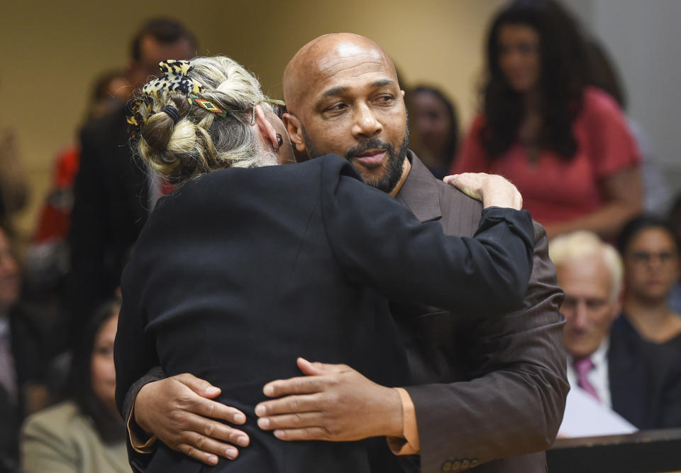 Keith Bush is embraced by his attorney, Adele Bernhard, Wednesday, May 22, 2019 at Suffolk County Courthouse in Riverhead, N.Y. after murder charges against him were vacated. Bush, who spent 33 years in prison for the 1975 murder of a high school classmate, had his conviction overturned Wednesday after a case review found Long Island prosecutors had long hid the fact that police looked at another possible suspect. (James Carbone/Newsday via AP, Pool)