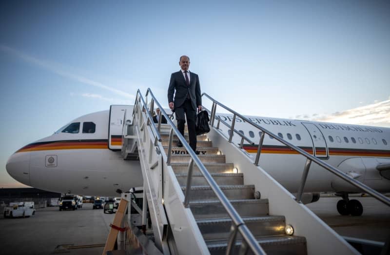 German Chancellor Olaf Scholz (L) steps out of an Airbus of the German Air Force's air force after arriving in Washington. Michael Kappeler/dpa