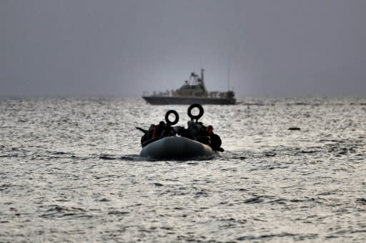 Refugees and migrants on a dinghy approach Mytilene on the northern island of Lesbos after crossing the Aegean sea from Turkey on February 19, 2016